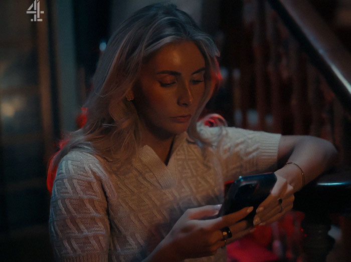 Woman with blonde hair in dim light focused on phone, body language expert analyzes sudden expression change in intense moment - 12
