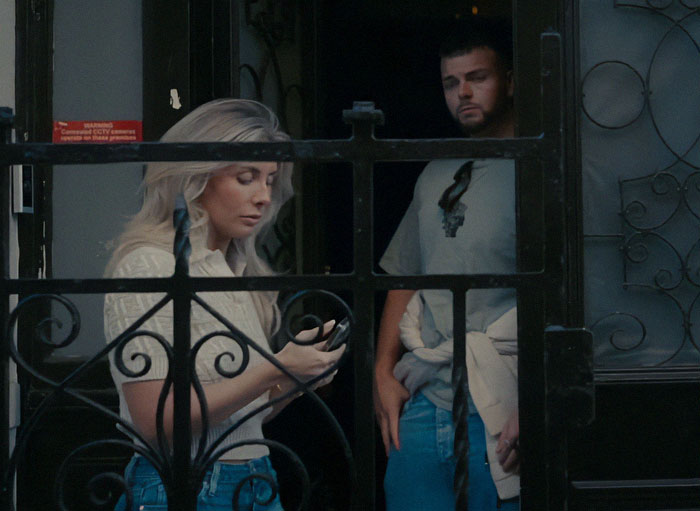 Woman with blond hair and man behind gate, body language expert decodes Bonnie Blue’s sudden expression change. - 4