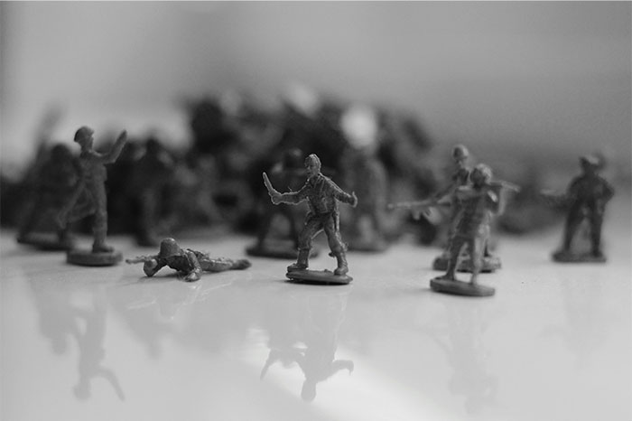 Small toy soldiers on a reflective surface illustrating the concept of profitable industries and strategic business sectors.