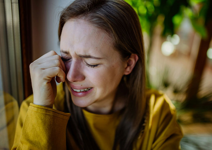 Woman faces heartbreak, crying by window, revealing true character of boyfriend after mother&rsquo;s death.