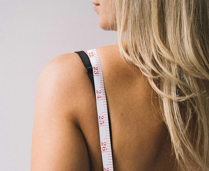 Woman with blonde hair and measuring tape around shoulder, relating to J.K. Rowling speaks out and alleged trans employee topic.