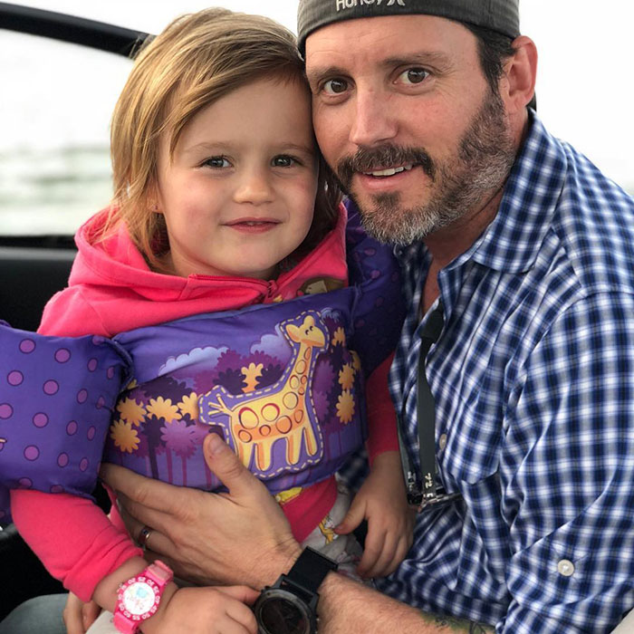 Man in checked shirt holding young child wearing a life jacket, highlighting Kelly Clarkson devastated for kids after ex’s passing. Man in checked shirt holding young child wearing a life jacket, highlighting Kelly Clarkson devastated for kids after ex’s passing.