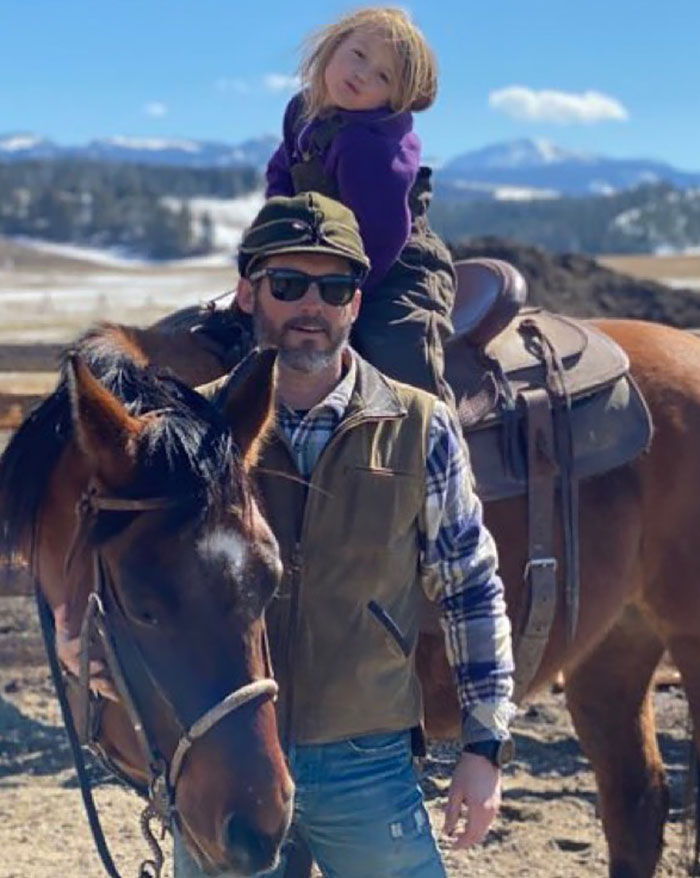 Man wearing sunglasses and vest stands beside horse with child on saddle, illustrating Kelly Clarkson devastated for kids after ex’s passing. Man wearing sunglasses and vest stands beside horse with child on saddle, illustrating Kelly Clarkson devastated for kids after ex’s passing.