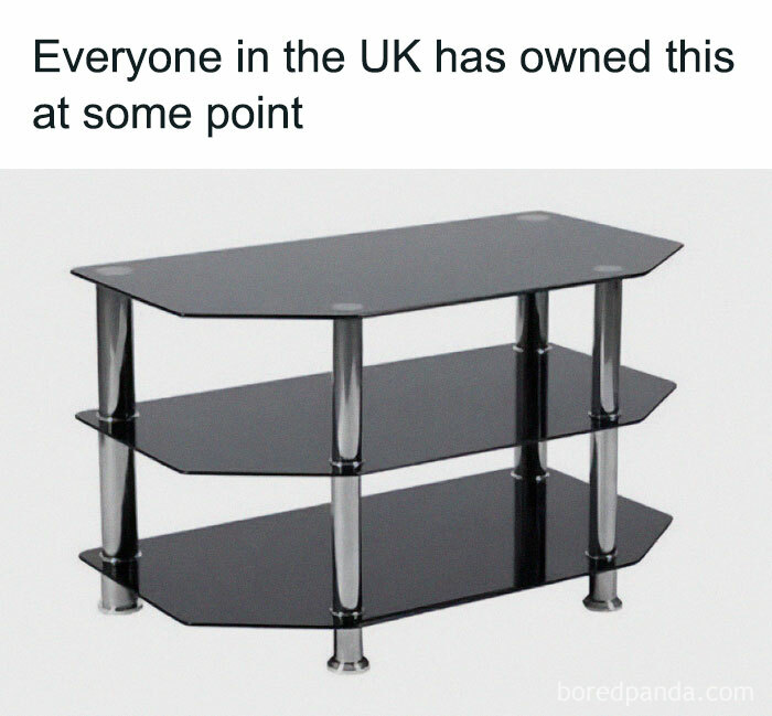 Black glass TV stand with metal legs, representing a funny meme about life in the UK and common household items.