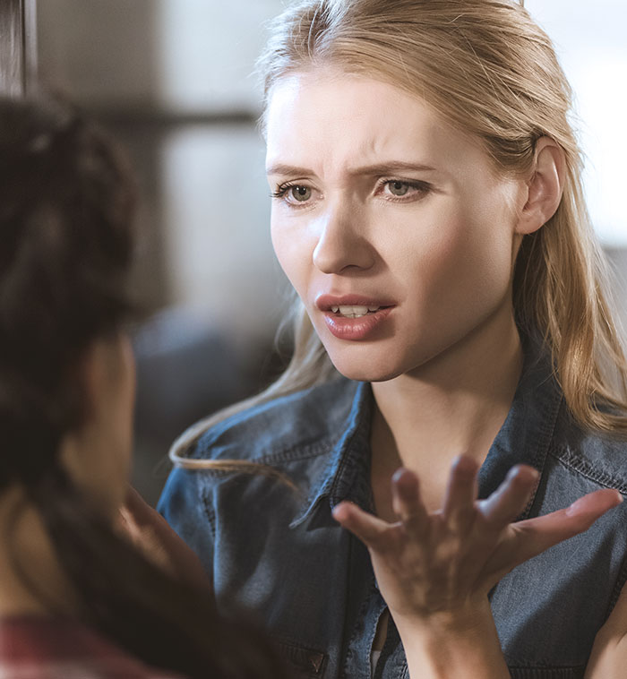 Woman confronting someone with an upset expression about copying her wedding dress in an intense conversation.