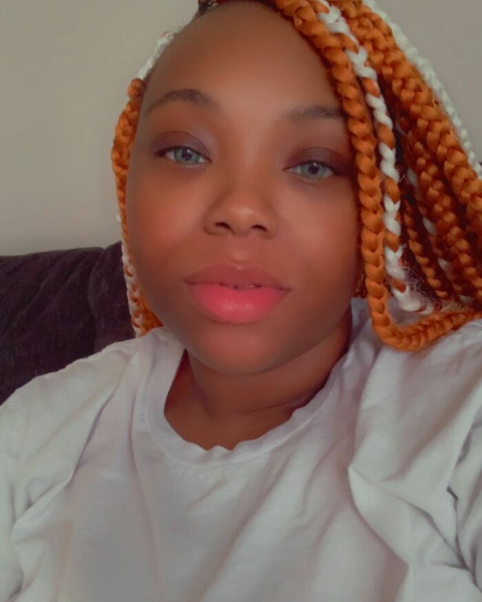 Young woman with braided hair, sharing emotional life update after Burger King employee viral performance and firing.