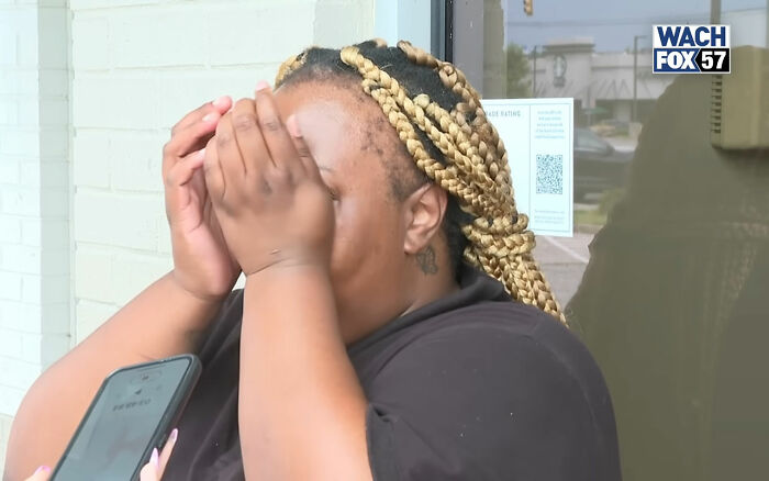 Burger King employee covering face during emotional update after viral 12-hour performance and firing.