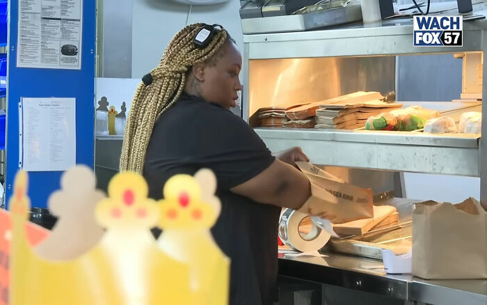 Burger King employee packing food bags inside restaurant kitchen during a work shift update.