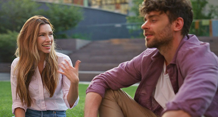 Two workers having an intense conversation outdoors, highlighting a gluten-free colleague issue at a pizza party. Two workers having an intense conversation outdoors, highlighting a gluten-free colleague issue at a pizza party.