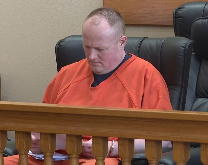 Man in orange prison jumpsuit seated in courtroom, related to stalker and captive woman case details.