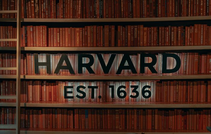 Harvard library shelves filled with books, highlighting a historic academic institution known for the smartest kids in class.