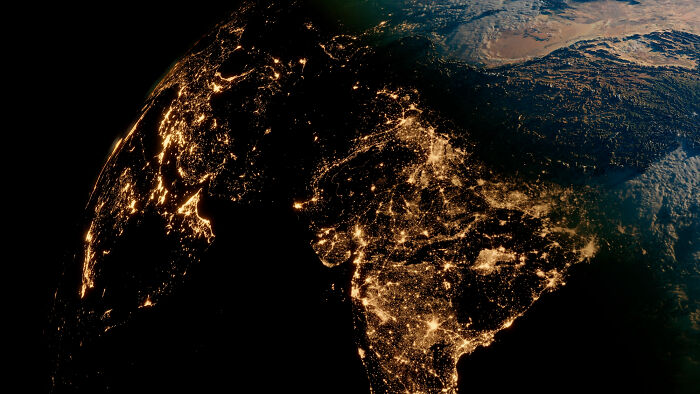 Earth at night showing illuminated cities across South Asia, illustrating concept time facts about global connectivity.