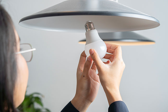 Person holding a light bulb and installing it into a ceiling lamp symbolizing conspiracy theorists being right moments