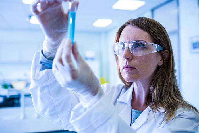 Scientist examining a test tube in a lab, representing conspiracy theorists being right in scientific discoveries.
