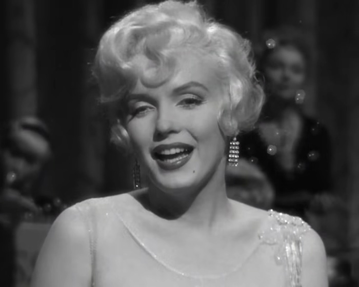 Black and white close-up of Marilyn Monroe smiling during a performance, related to autopsy suspicious finding revelations. - 6