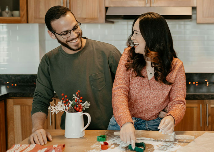 Couple enjoys baking together in a kitchen, sharing moments of joy and connection in their rags to riches relationship.