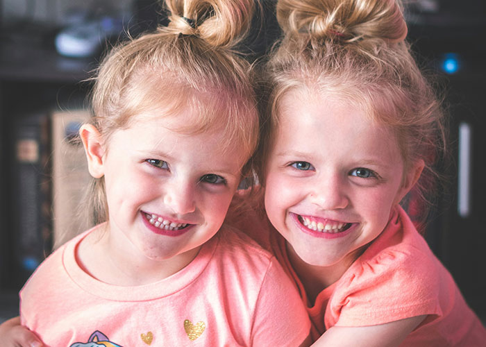 Two smiling young girls with blonde hair in pink shirts, illustrating examples from jam Metallica horrible names.