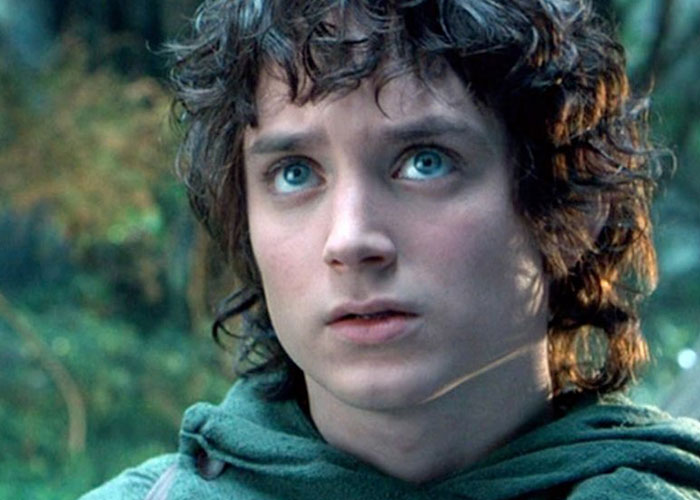 Close-up of a young person with curly hair and blue eyes outdoors, representing unusual names causing lifelong pain.