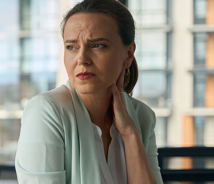 Worried woman in office setting reflecting on the creepiest parts of their jobs shared by 92 workers.