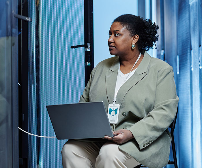 Woman in an office setting working on a laptop, illustrating workers revealing the creepiest parts of their jobs.