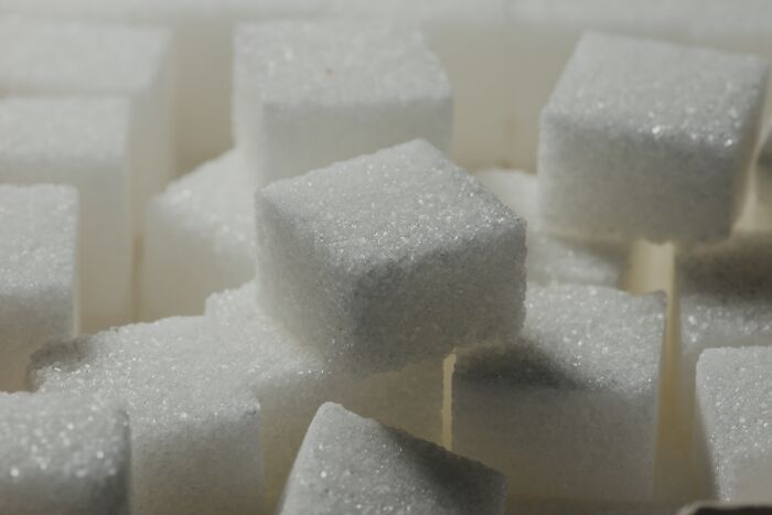 Close-up of white sugar cubes stacked together, illustrating concepts related to shopping and addictive habits.