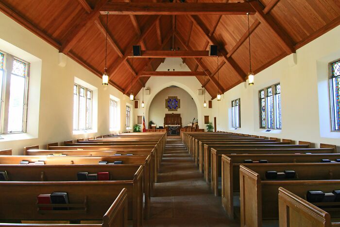 Interior of a quiet church with wooden pews and stained glass windows, illustrating disturbing facts shared by people.