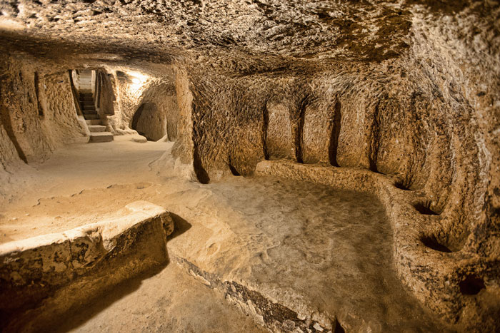 Ancient mysterious underground city interior with carved walls and narrow passageways, 18 stories and 280 feet deep.