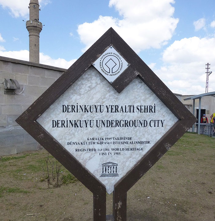 Sign at Derinkuyu Underground City entrance, highlighting the mysterious underground city's depth and historic significance.