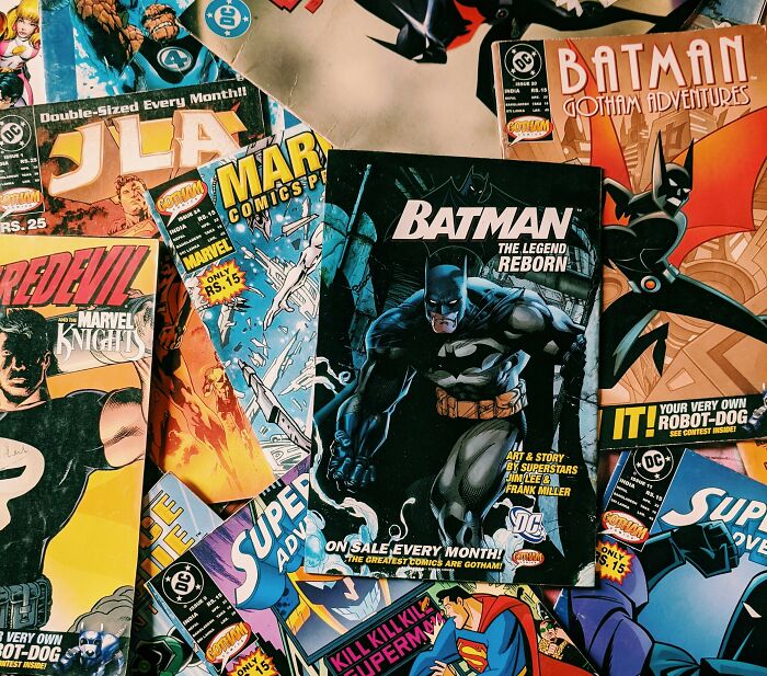 Collection of classic comic books featuring Batman and other superheroes showcasing unhinged hacks done land job themes.