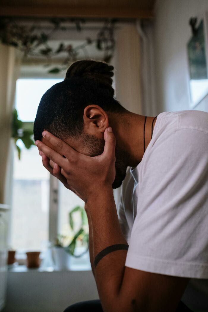 Man covering his face in distress, reflecting on a disgusting truth about a friend that ended their relationship.