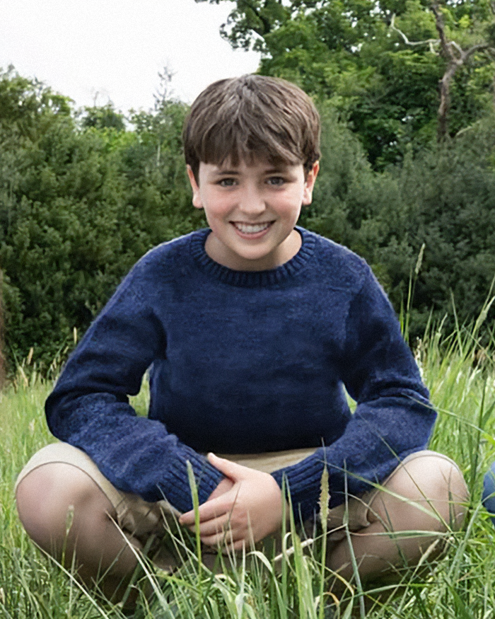Young actor sitting in grass wearing a blue sweater, part of new photos from the Harry Potter series set sparking mixed reactions. Young actor sitting in grass wearing a blue sweater, part of new photos from the Harry Potter series set sparking mixed reactions.