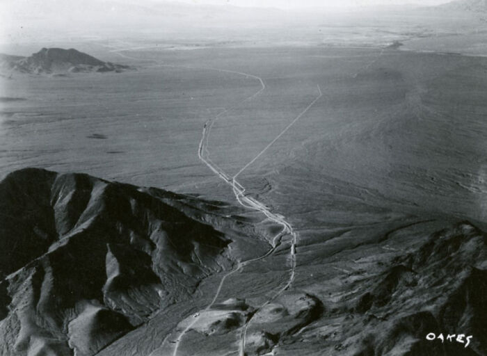 Aerial view of the barren desert landscape showing early roads and rugged terrain in the birth of Vegas historic period.