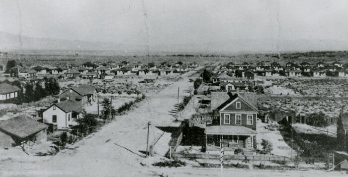 Early 1900s historic photo showing the birth of Vegas with sparse houses and unpaved streets in a desert landscape.