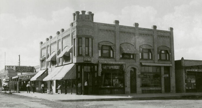 Historic black and white street scene showing early 20th century buildings during the birth of Vegas era.