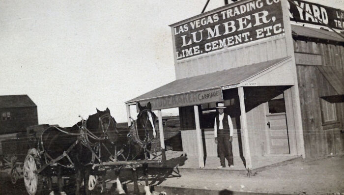 Early Las Vegas trading company with horses and a man outside a lumber and cement store, showcasing historic Vegas birth.