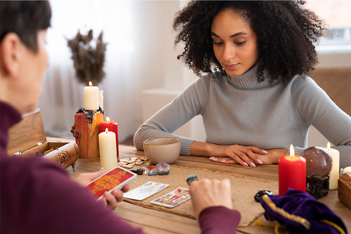 Woman watching tarot cards during a reading while discussing bizarre reasons for someone wanting a divorce.