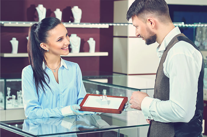 Jewelry store assistant showing a necklace to a customer, illustrating bizarre reasons people wanted a divorce.