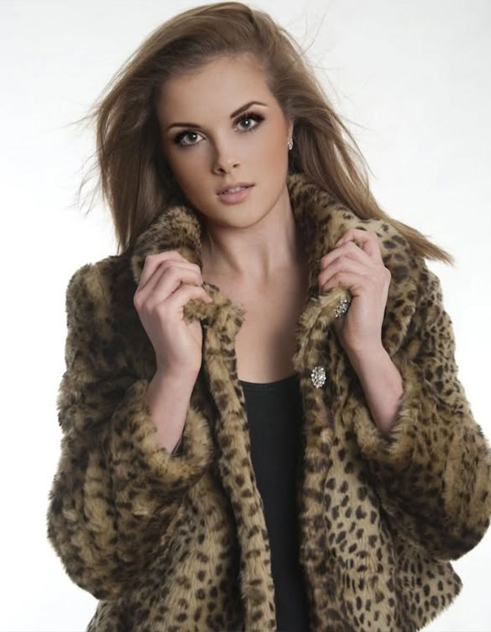 Young woman wearing a leopard print fur coat posing against a plain background, representing rare disorder pain awareness. Young woman wearing a leopard print fur coat posing against a plain background, representing rare disorder pain awareness.