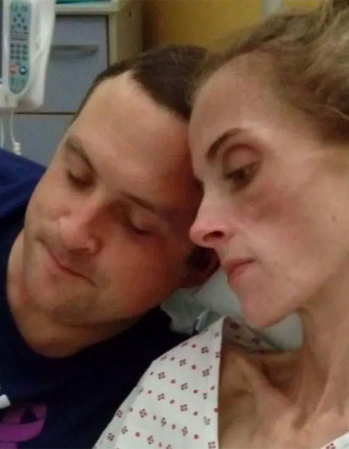 Woman in hospital gown resting with man nearby, highlighting rare disorder and dismissed pain in medical setting. Woman in hospital gown resting with man nearby, highlighting rare disorder and dismissed pain in medical setting.