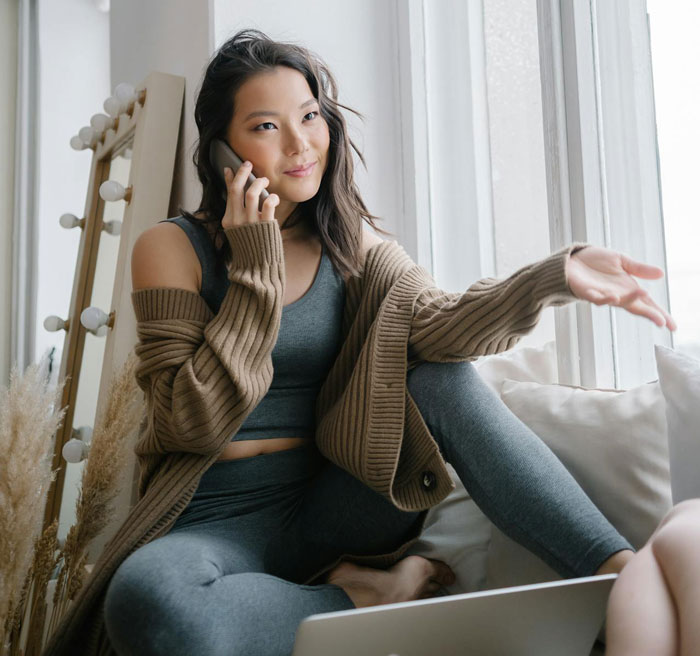 Young woman talking on phone by window, reflecting on hosting old friend and handling unexpected wild requests. Young woman talking on phone by window, reflecting on hosting old friend and handling unexpected wild requests.
