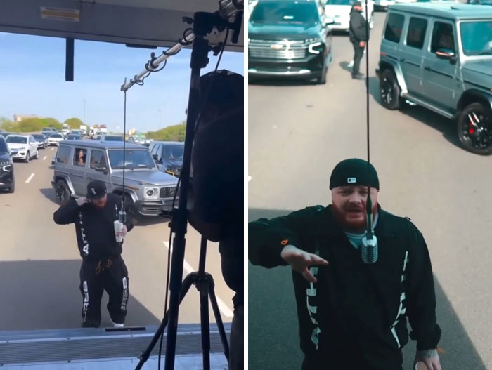 Man standing dangerously in traffic between cars, showing disregard for rules and etiquette on busy road.