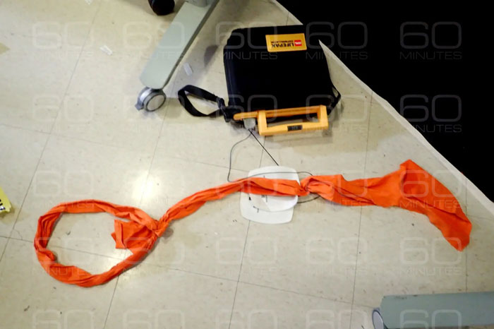Orange fabric noose and black bag on jail floor, highlighting missing minutes in Epstein jail video doubts. - 5
