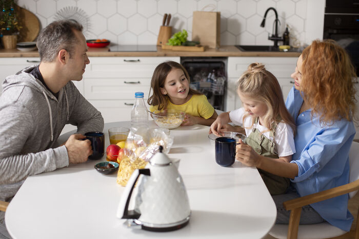 Family enjoying breakfast together in a kitchen, illustrating the concept of words that don’t exist in English but are used in other languages.