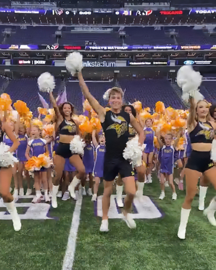 Male cheerleaders performing with female cheerleaders at an American football game, highlighting male infiltration of women&rsquo;s spaces.