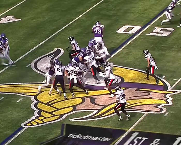 Football players in action on the field with a focus on male cheerleaders infiltrating women's spaces debate.