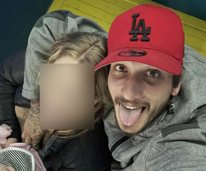 Young dad wearing red cap smiling in selfie, related to tragic story of dad losing life after being buried alive in sand.