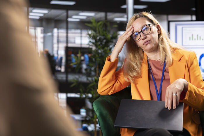 Hiring manager in an office setting looking frustrated while dealing with difficult people during a work meeting.