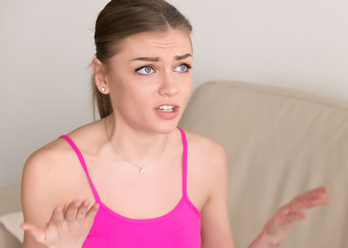 Young woman in pink top looking upset and confused, capturing the bride&rsquo;s world crumbling moment after secrets revealed.