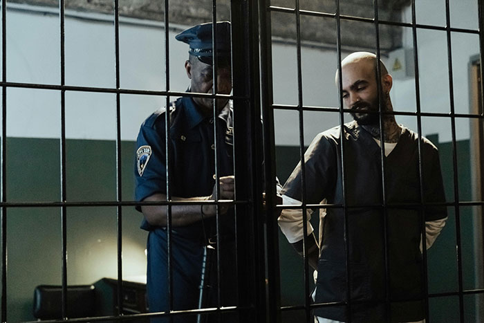 Prison officer escorting an inmate behind bars, illustrating insights into what life in prison is like.