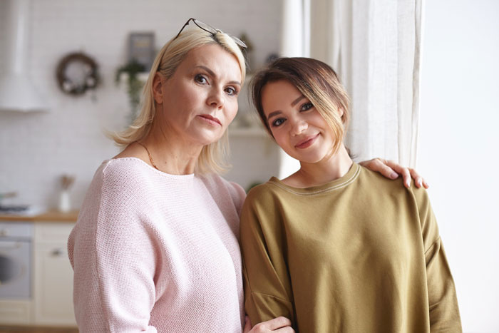 Two women standing close together near a window, representing support and free salon service marriage connection. Two women standing close together near a window, representing support and free salon service marriage connection.
